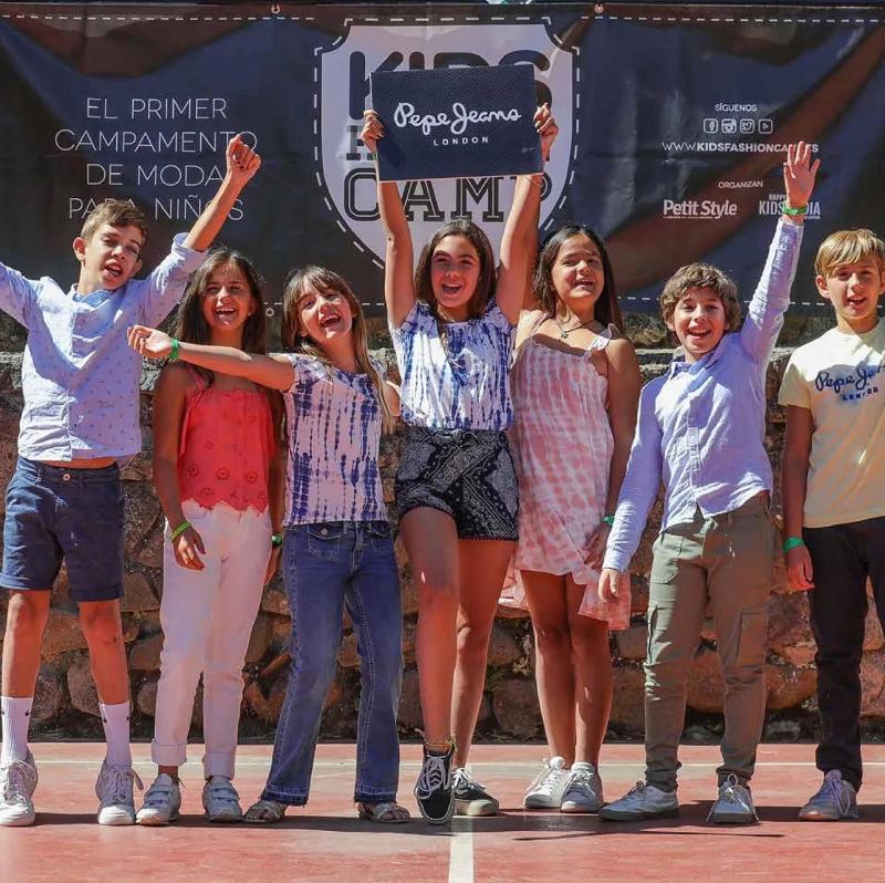 Una foto de un grupo de niños posando a cámara en un campamento de diseño y moda para niños 