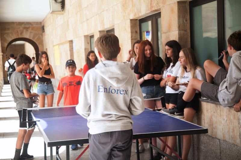 Un grupo de jovenes jugando al ping pong en un campamento de verano en salamanca