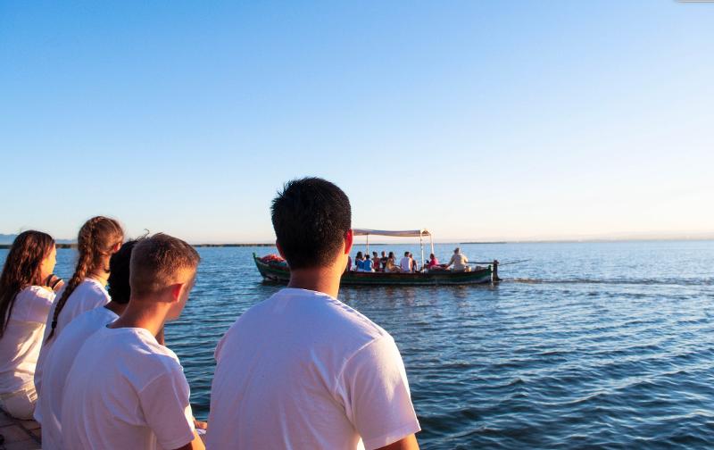 Un grupo de jovenes mirando a un barco en un campamento de verano en valencia
