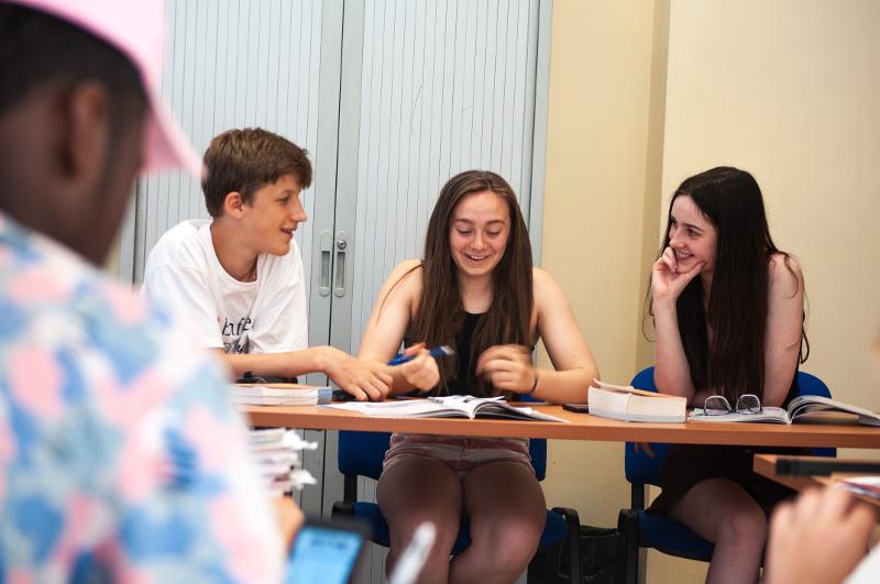 Un grupo de jovenes riendo en una clase de idiomas en un campamento verano valencia