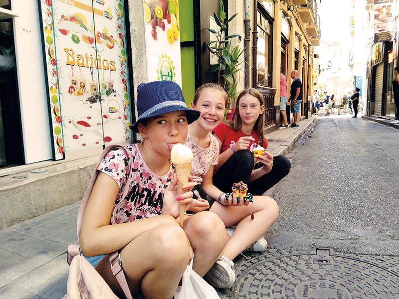 Tres niñas comiendo helado en las calles de malaga en un campamento de verano en malaga