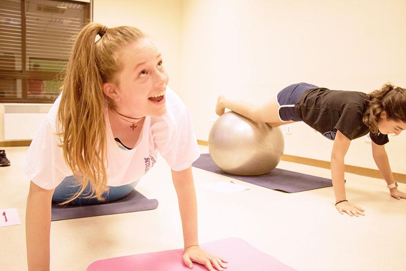 Una niña practicando yoga en una clase de yoga en un campamento de verano malaga