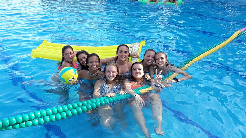 Una foto de unos jovenes en una piscina mirando a camara en un campamento de verano marbella
