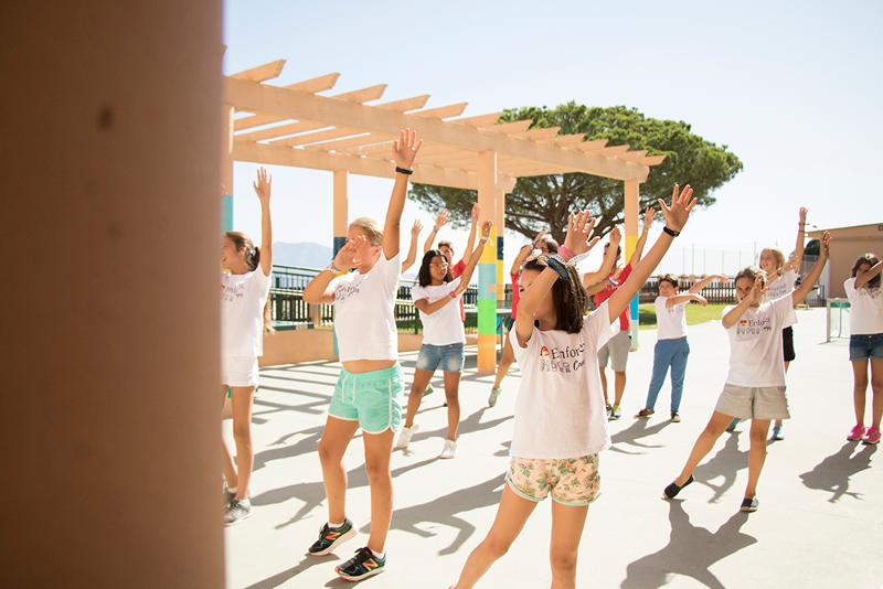 un grupo de niños bailando en un campamento de verano marbella