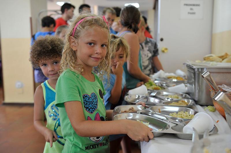 Niños mirando a camara en un comedor en un campamento de verano marbella