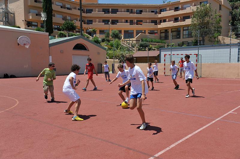 Niños jugando al futbol en un campamento de verano marbella