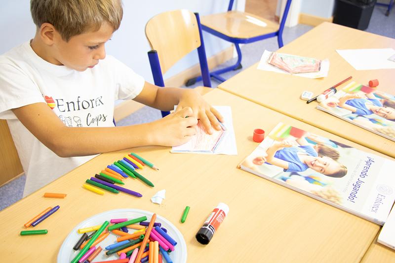 Un niño pintando con ceras en una clase de pintura en un campamento de verano en marbella