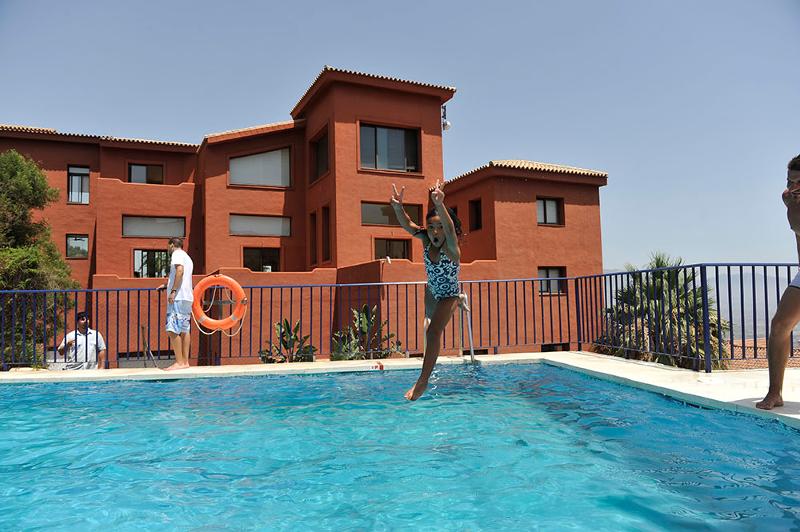 Una niña saltando a la piscina en un campamento verano marbella