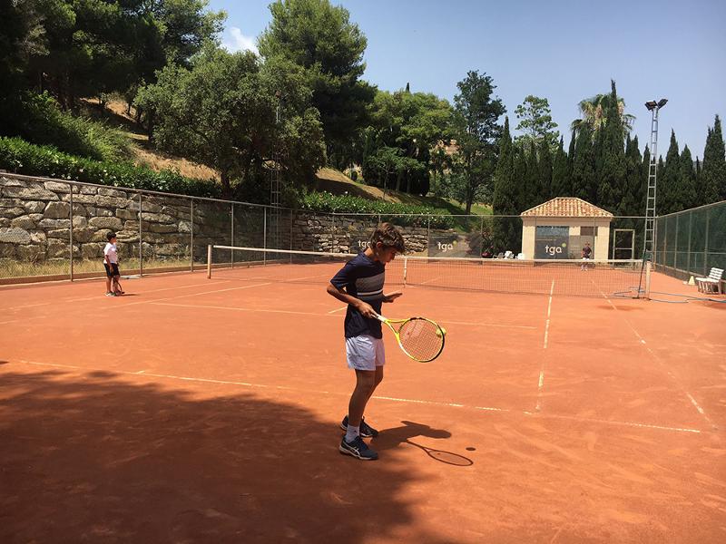 Un niño jugando al tenis en un campamento verano marbella