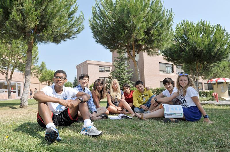 Jóvenes sentados en el césped posando en el campamento de verano comunidad de madrid
