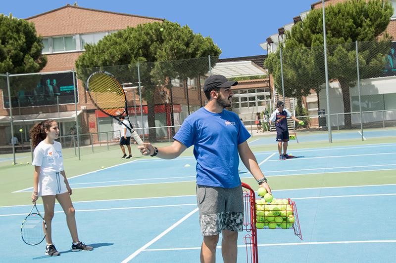 Profesor de tenis dando clase en el campamento verano comunidad madrid