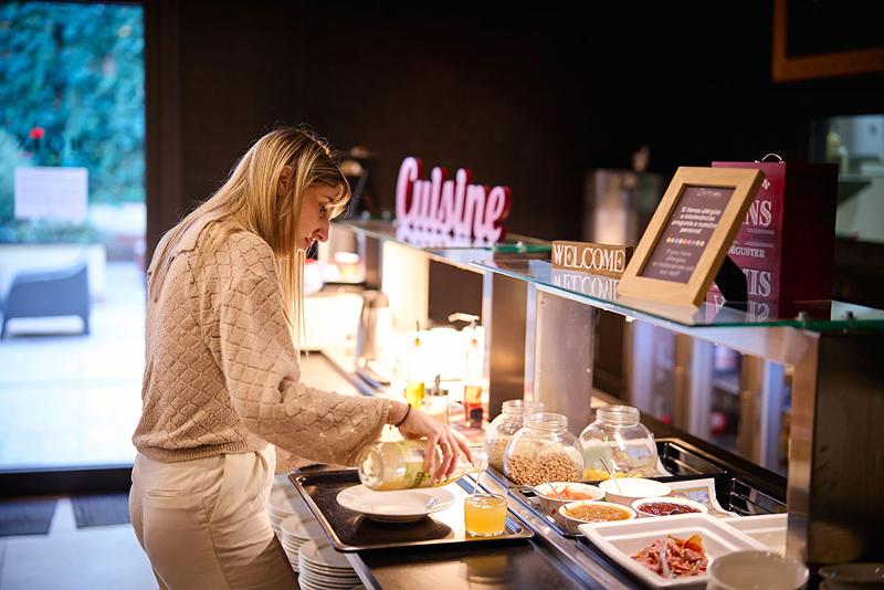 una chica sirviéndose una bebida en un comedor tipo buffet en un summer camp barcelona