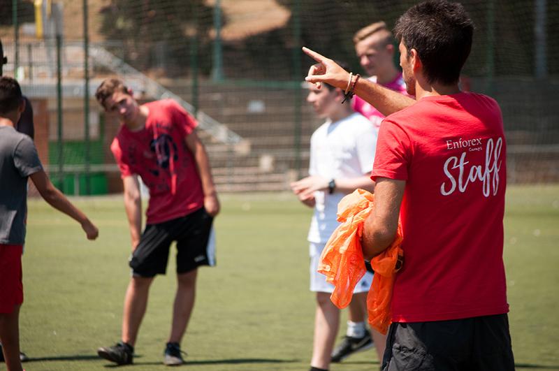 un grupo de jovenes jugando al futbol en un campamento de verano