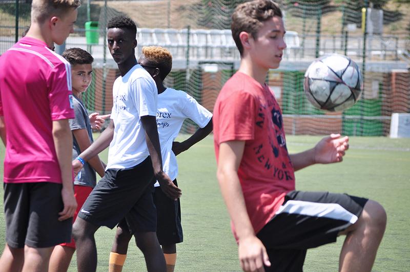 Un grupo de niños jugando al futbol en un campamento de verano