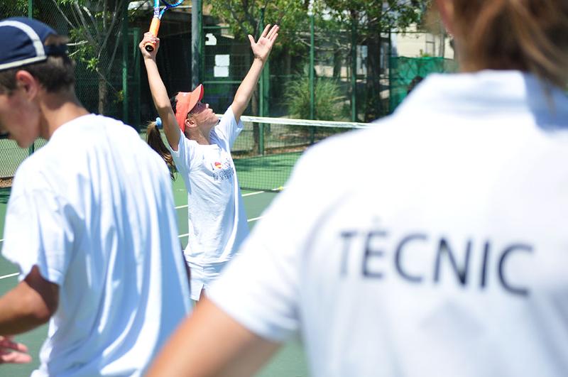 Un grupo de niños jugando al tenis en un campamento de verano de tenis