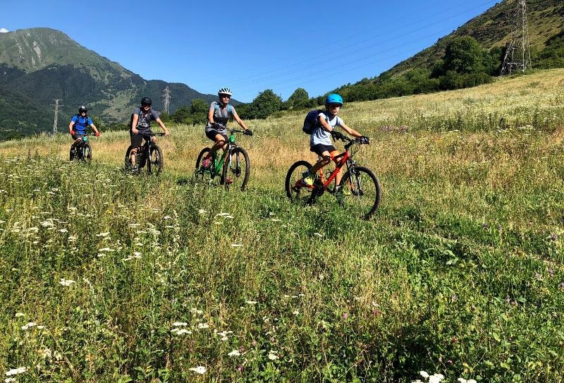 Jóvenes montando en bici en los Alpes en unas vacaciones ski