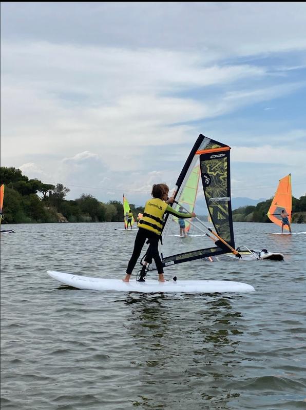 Una niña navegando en un campamento de windsurf