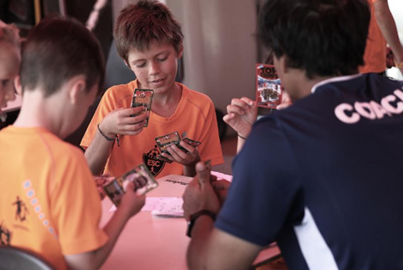 Niño jugando a las cartas en el campamento fútbol inglés verano