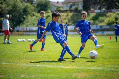 niños en el campo de futbol jugando durante el campamento de verano en alemania