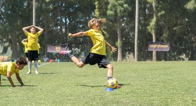 Niño preparándose para lanzar el balón con el pie en el summer camp marbella