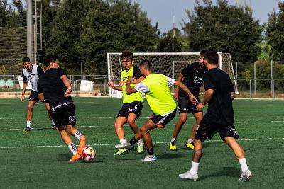 Grupo de futbolistas disputando la pelota durante un campamento de futbol
