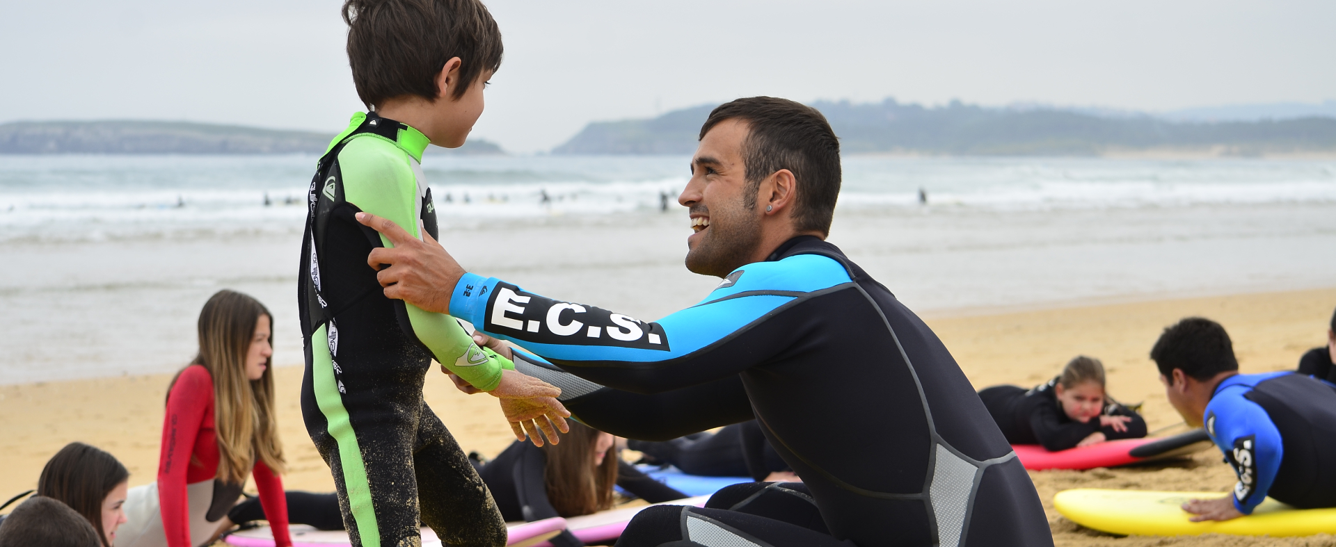 Instructor de surf ayudando a pequeño participante