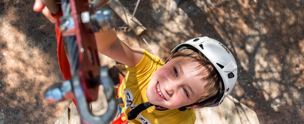 Niño practicando actividades de escalada en su campamento de verano