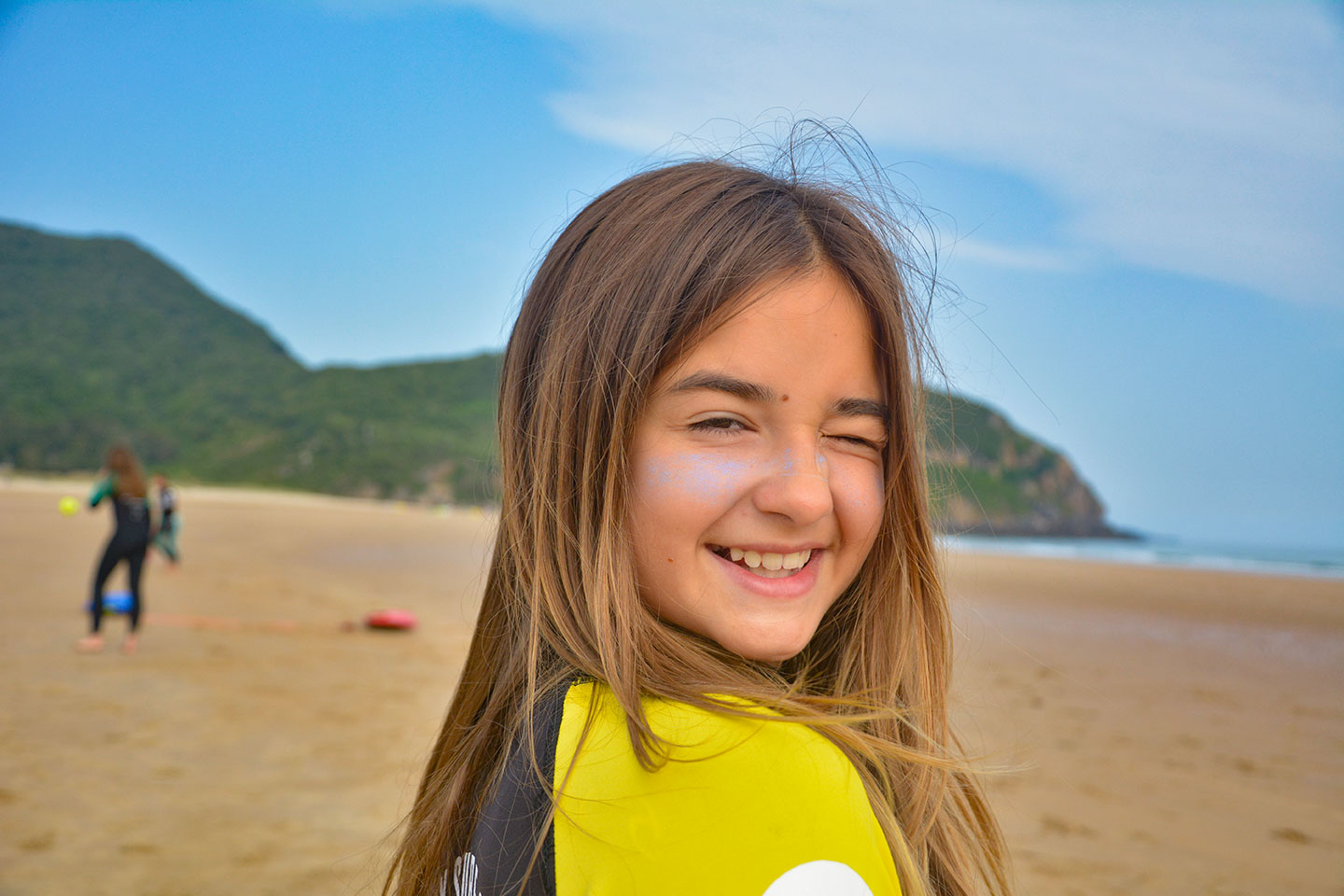 Niña sonriente tras participar en una actividad de surf