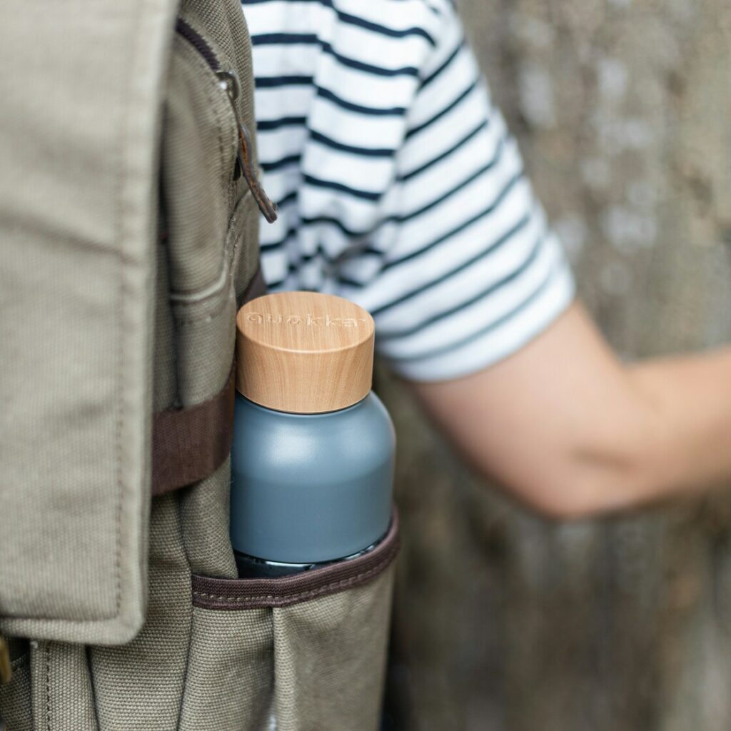 Un niño llevando en su mochila una botella de agua en un viaje escolar